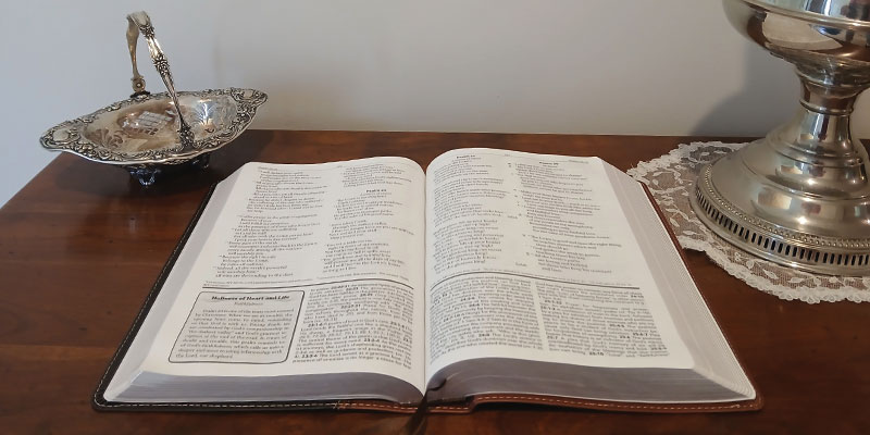 Open-Bible-on-table-with-lamp-and-bowl